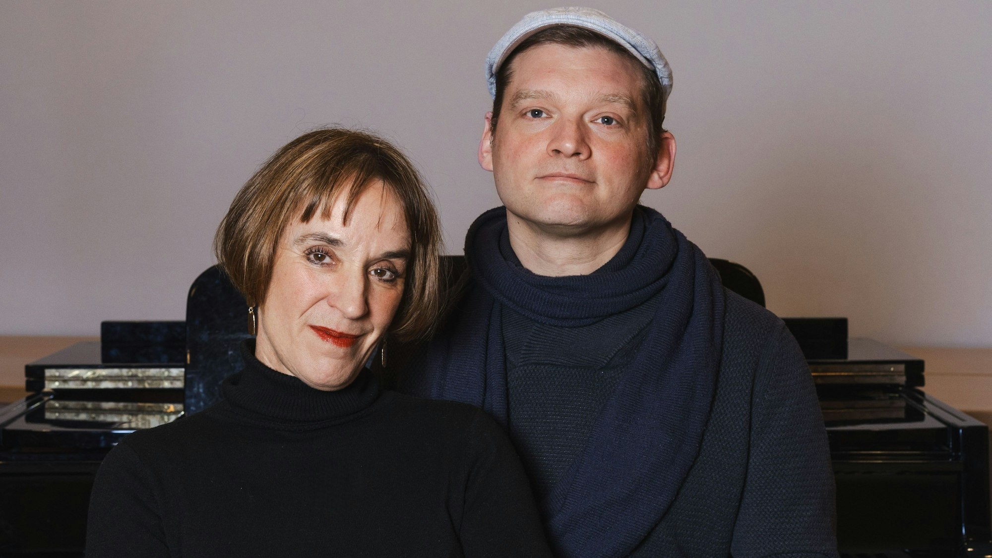 Eine Frau mit Pagenschnitt und ein Mann mit Schiebermütze.