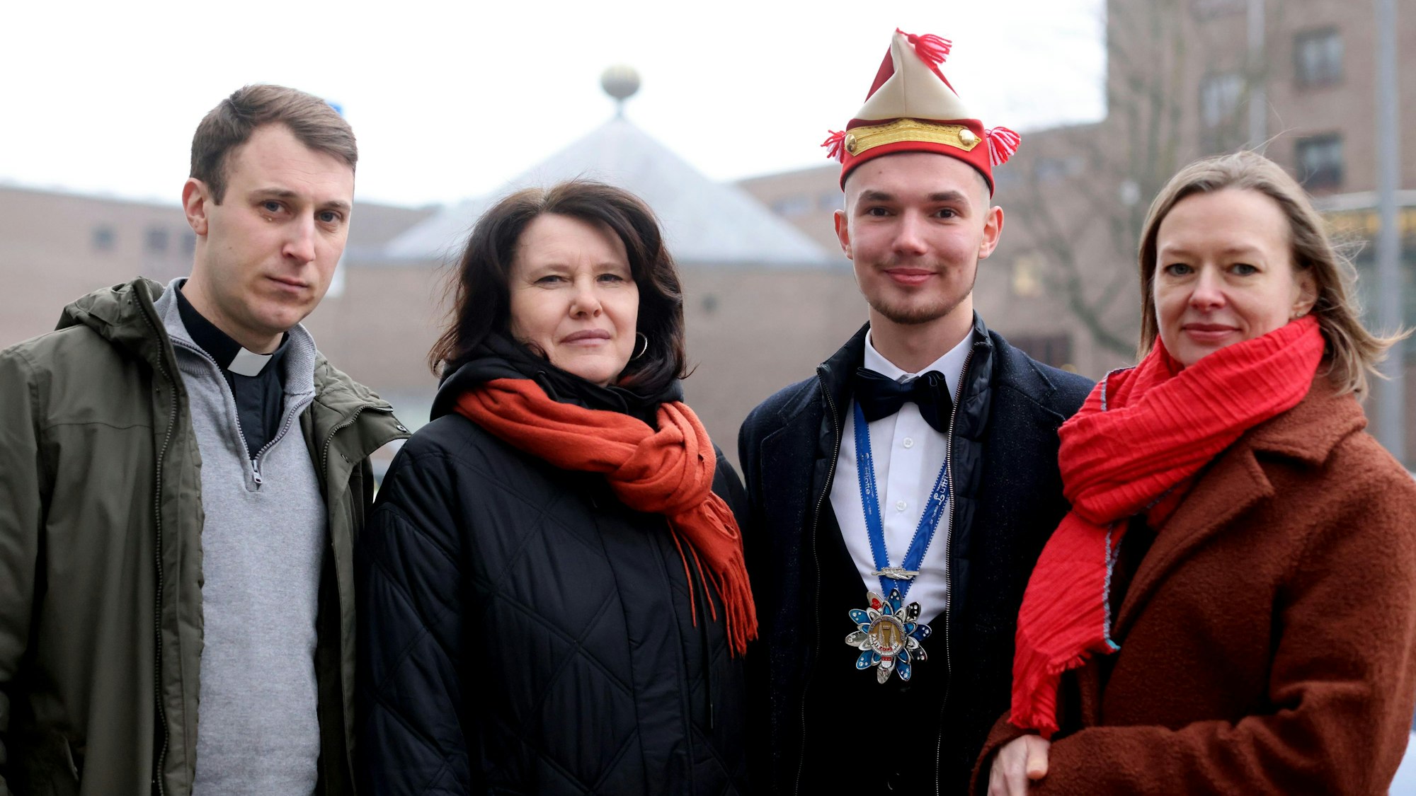Nataliia, Yehor und Svitlana stehen mit Priester Hennadii Aronovych vor dem Maternushaus in Köln.