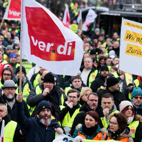 Mitglieder verschiedener Berufsgruppen demonstrieren mit Verdi- Fahnen.
