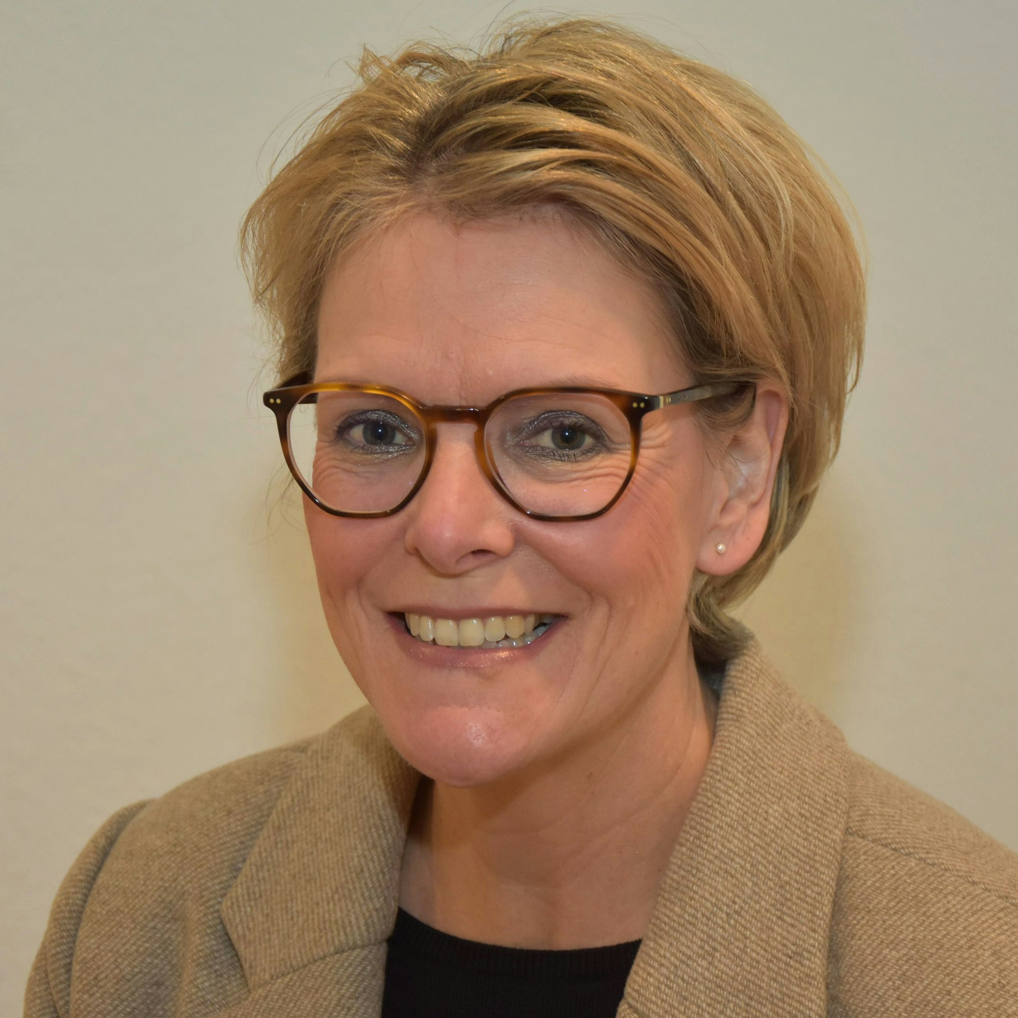 Eine blonde Frau lächelt.