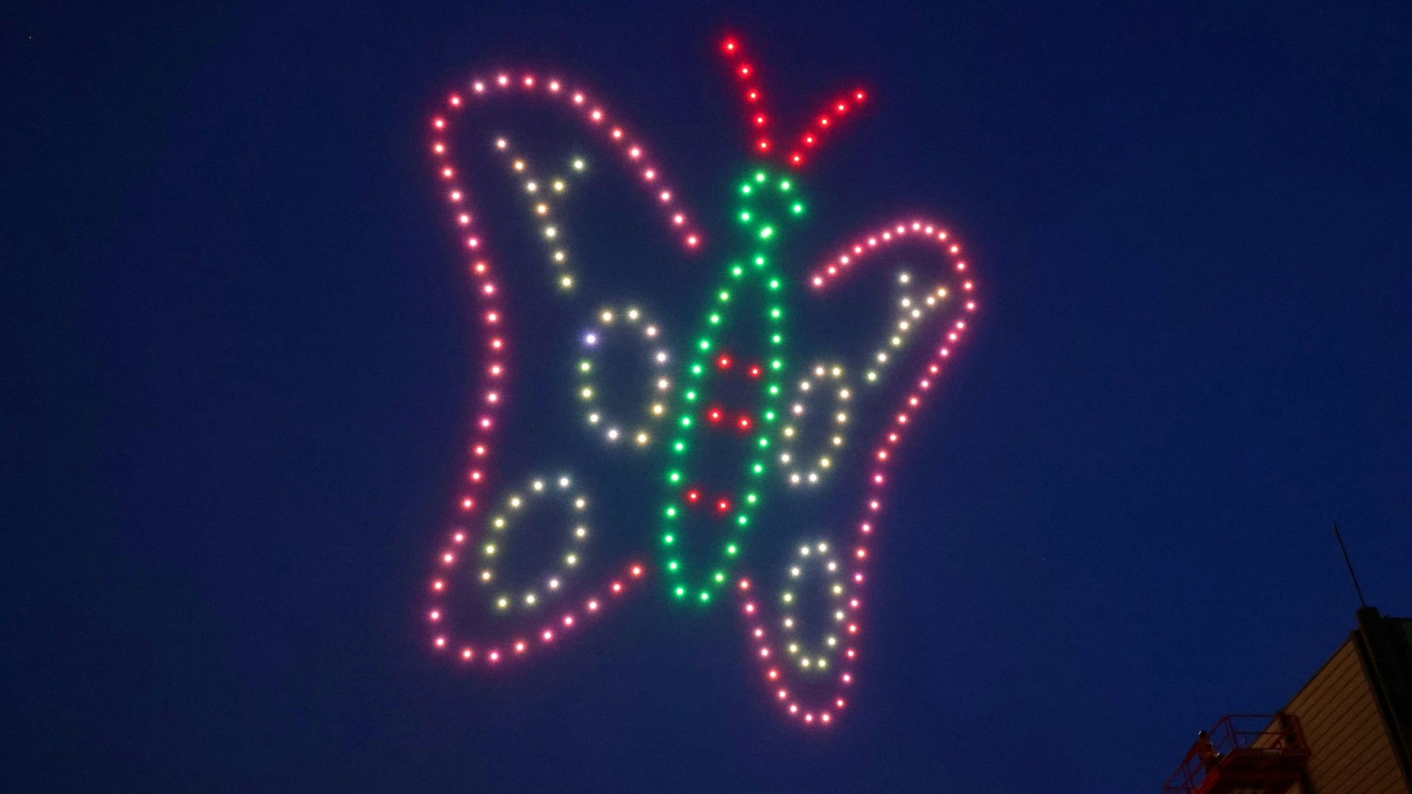 19.02.2025, Nordrhein-Westfalen, Düsseldorf: Über der Messe in Düsseldorf fliegen 200 Drohnen im Form eines bunte Schmetterlings im Rahmen der Industriemesse Xponential. Die Drohnen formten in 90 Metern Höhe unter anderem die Skyline von Düsseldorf, einen Schmetterling sowie eine Weltkugel. Foto: David Young/dpa +++ dpa-Bildfunk +++