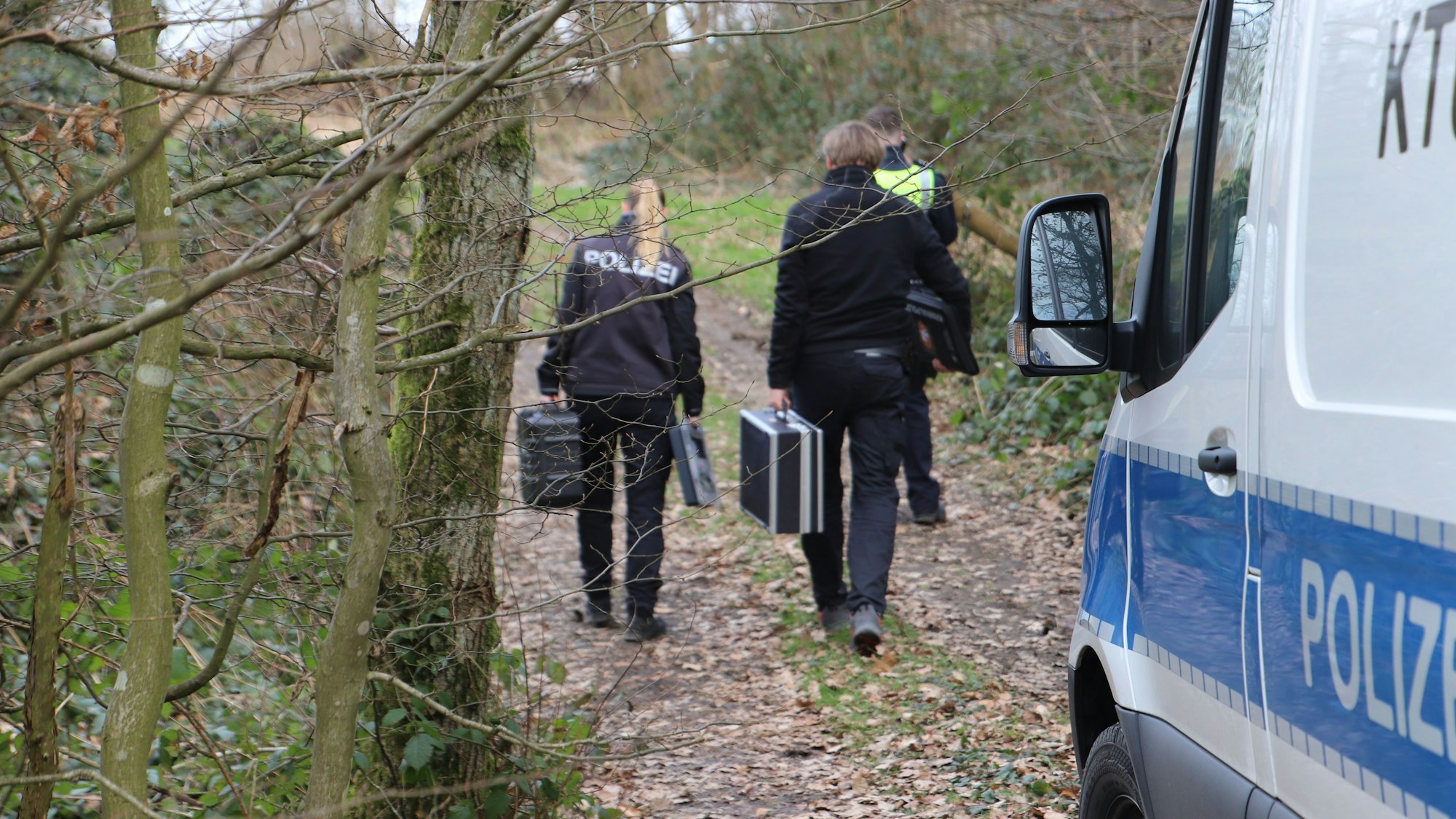 Ermittler der Polizei und der Spurensicherung auf dem Weg zum Tatort in einem Weiler bei Ruppichteroth.