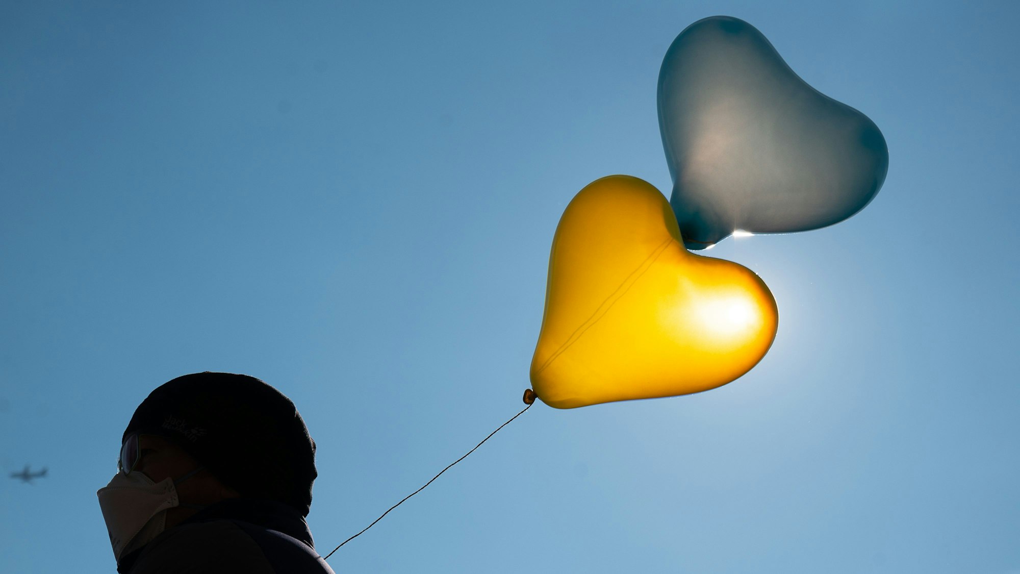 Mainz: Ein Mann trägt während einer Demonstration gegen den russischen Angriff auf die Ukraine Luftballons in den Farben der Ukraine.
