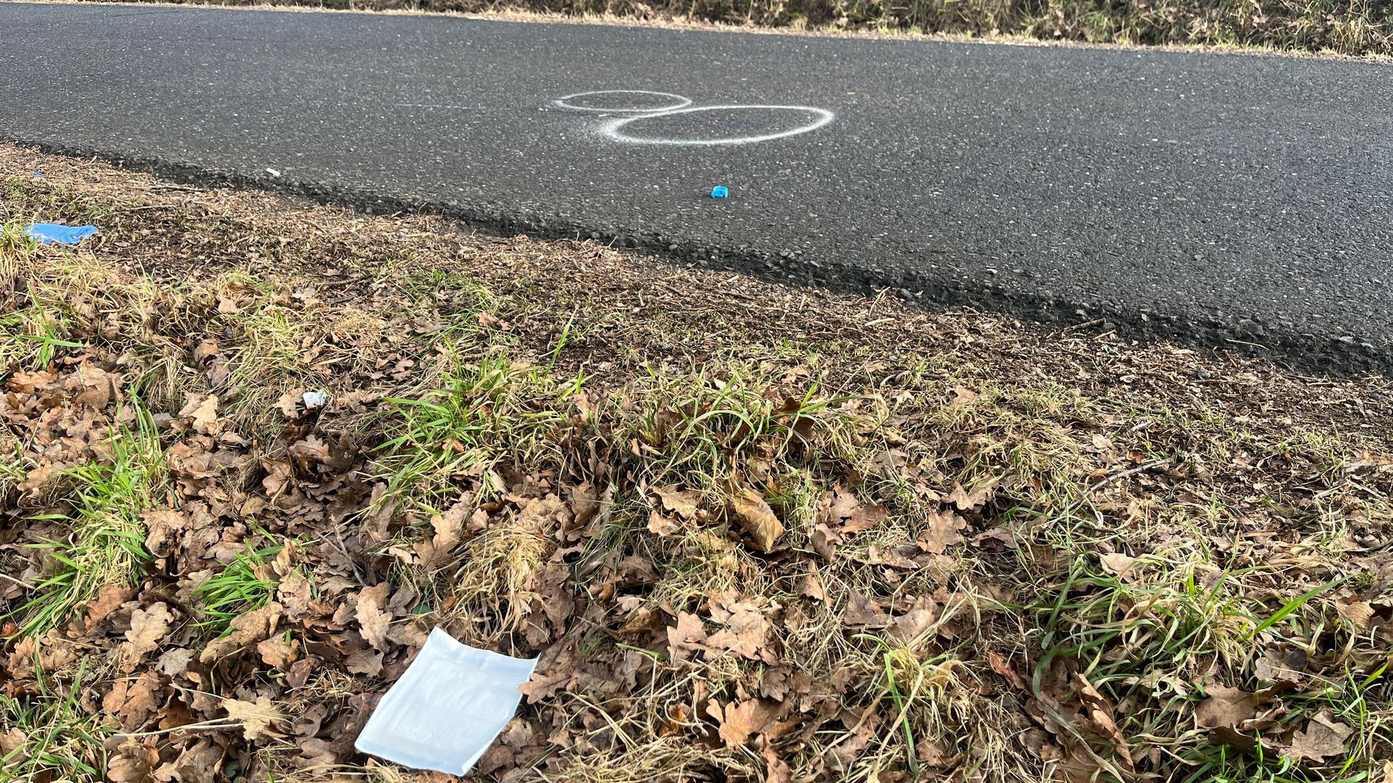 Weiße Kreidekreise sind auf einer schmalen Straße zu sehen.