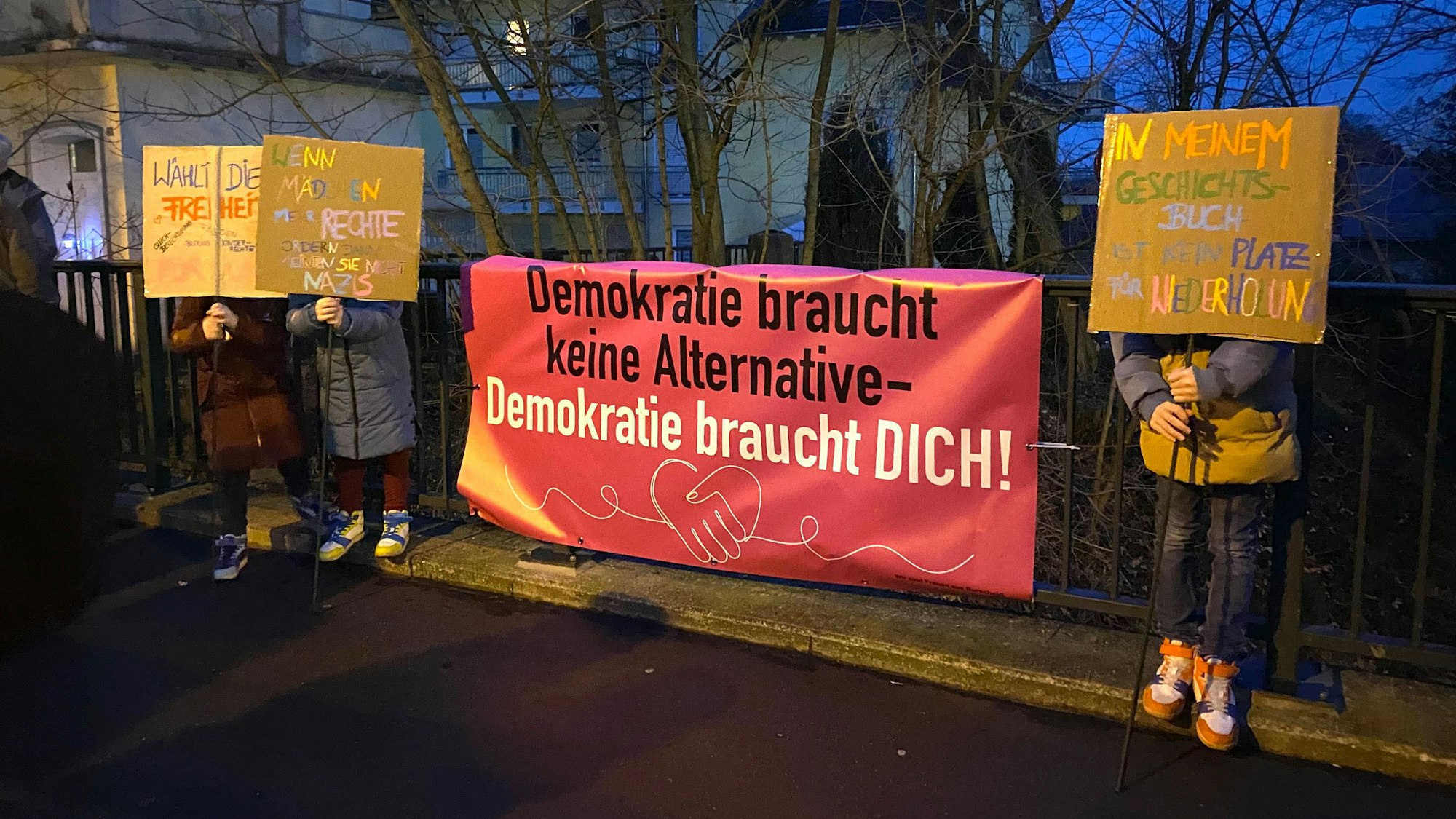 Neues Banner der 'Burscheider Frauen' mit den selbstgemachten Plakaten von mehreren Kindern