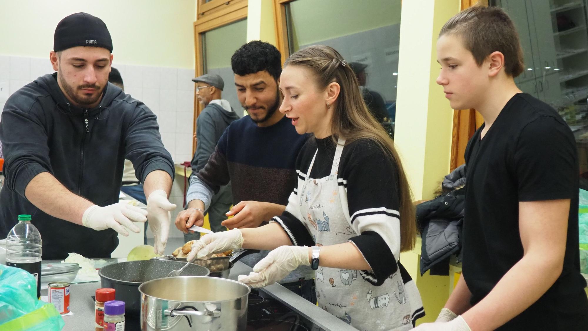 Zwei Frauen und zwei Männer kochen gemeinsam.