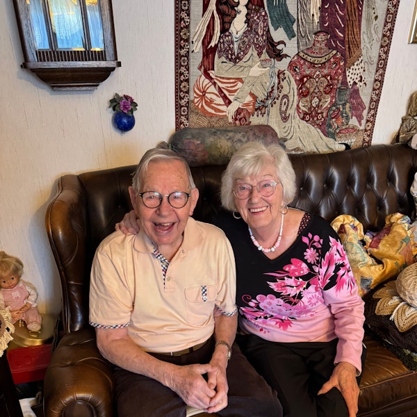 Ein Ehepaar sitzt auf einer Couch.