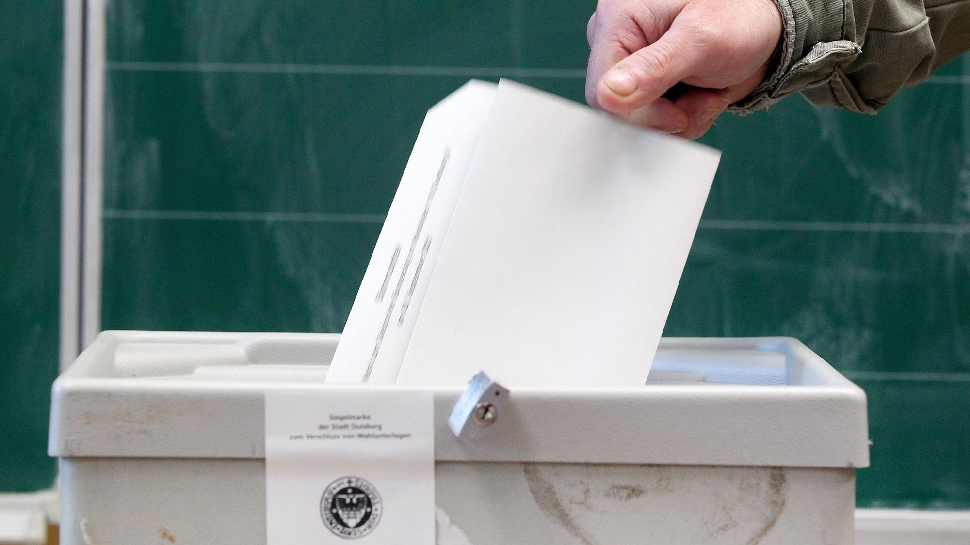 Ein Wähler wirft seinen Stimmzettel in einem Wahllokal in die Wahlurne.