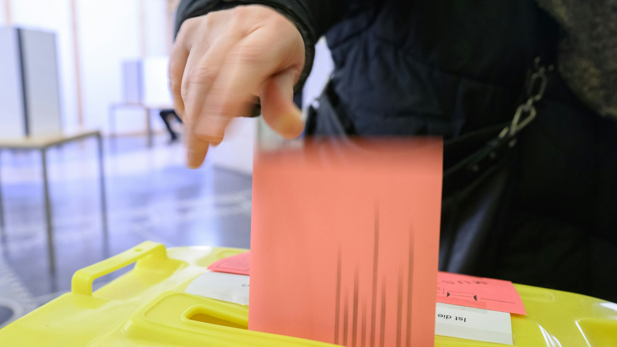 Eine Frau wirft ihren Wahlzettel für die Bundestagswahl 2025 in eine Urne.