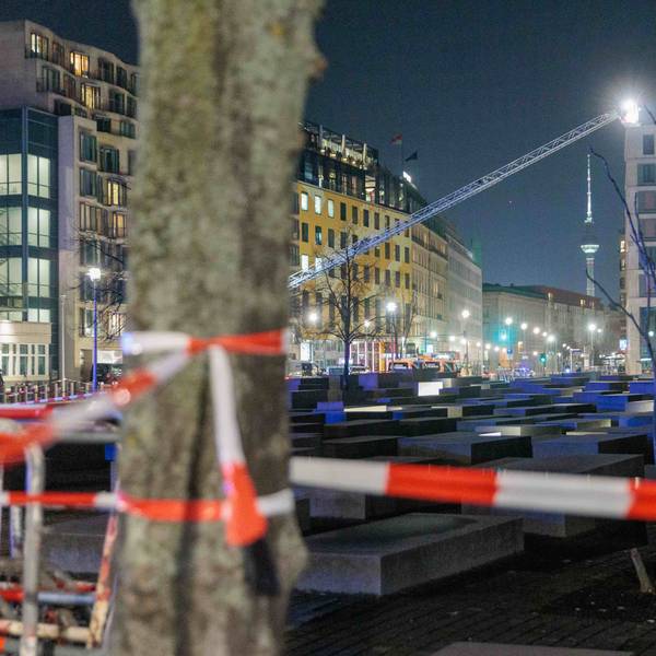 Polizeikräfte und Feuerwehr sichern das Holocaust-Denkmal. Von einer Hebebühne aus durchsuchen sie mit Scheinwerfern das Gelände ab.