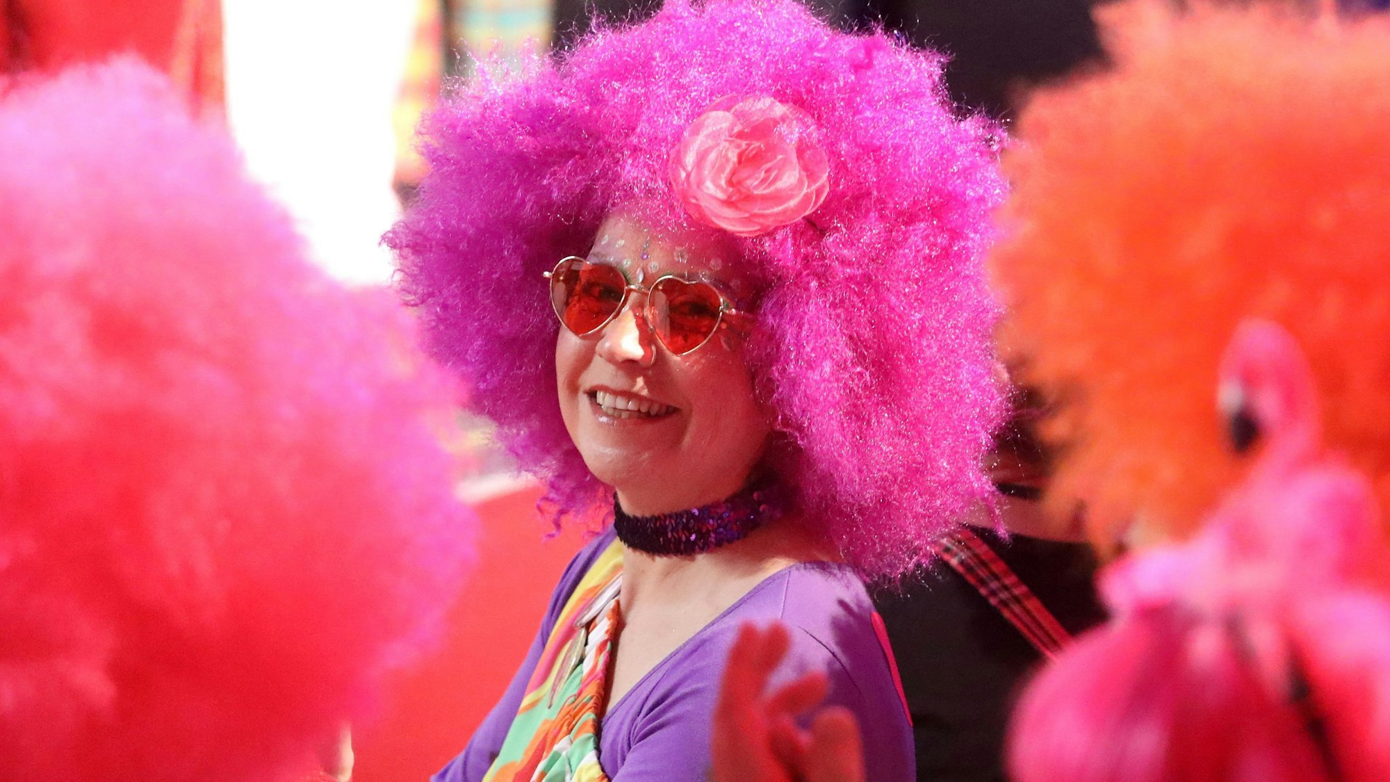 Eine Jeckin mit pinkfarbener Perücke.