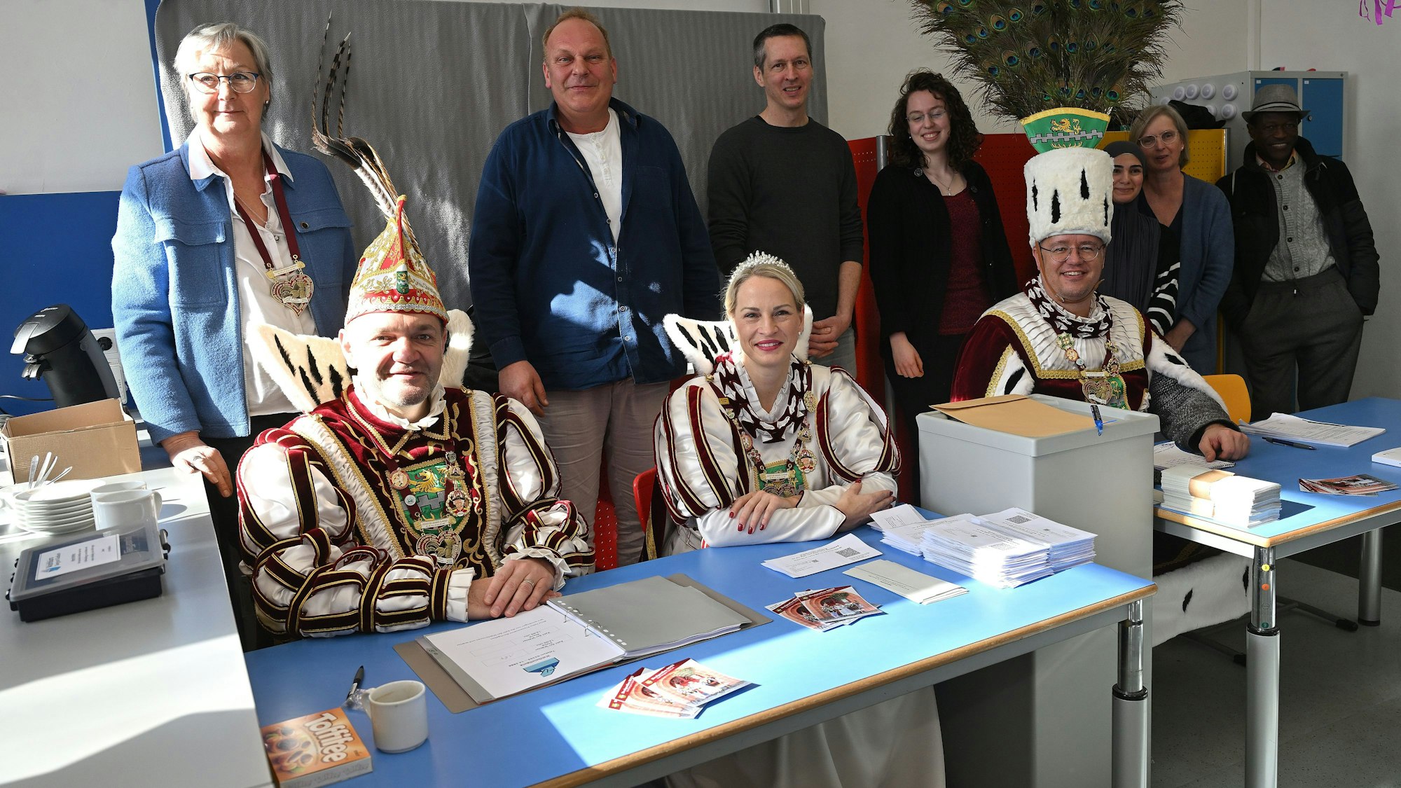 Bergisch Gladbachs Dreigestirn sitzt am Sonntagnachmittag (23.2.) am Tisch des  Wahlvorstand (stehend dahinter) in der Grundschule im Bergisch Gladbacher Stadtteil Gronau.