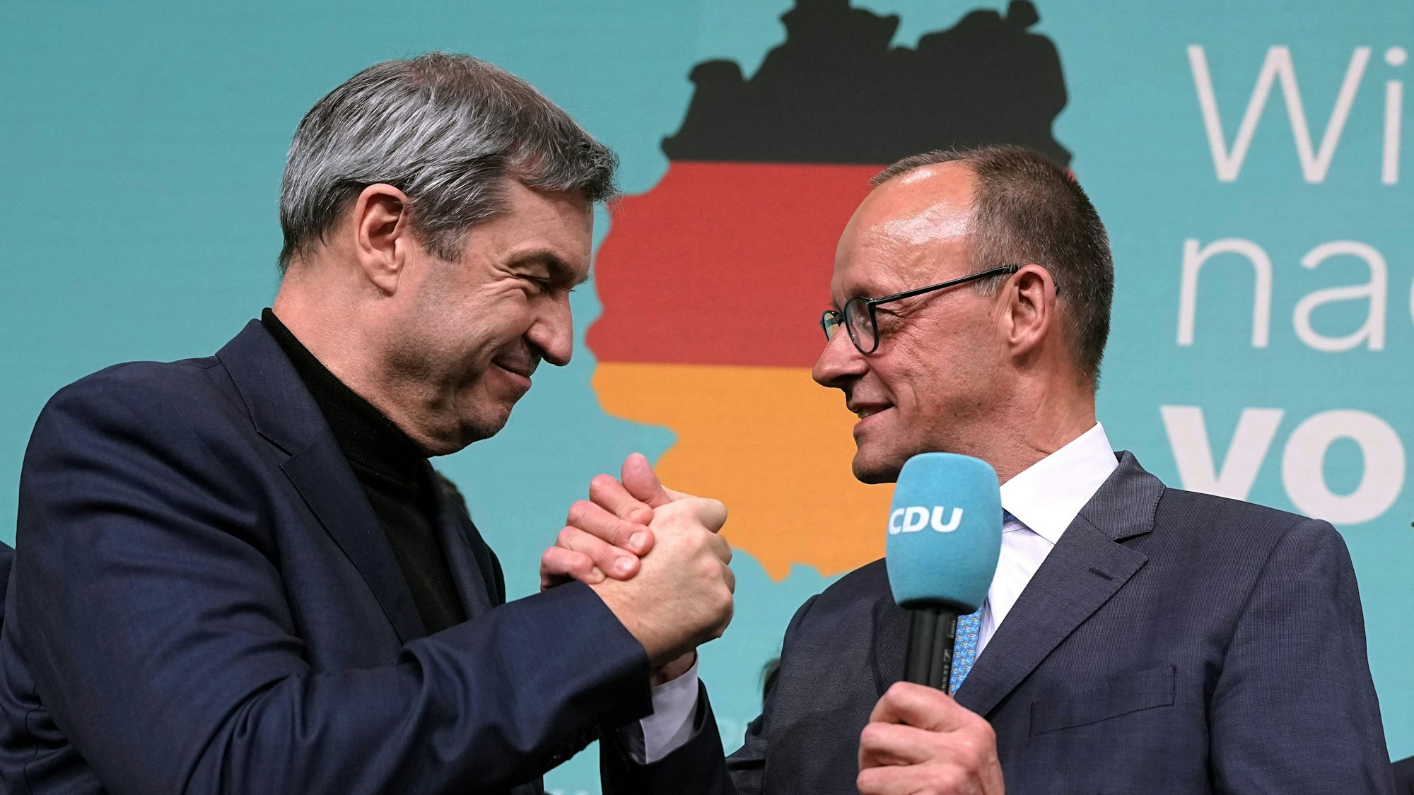 Berlin: Friedrich Merz (CDU, r), Parteivorsitzender und Kanzlerkandidat, gibt Markus Söder, Ministerpräsident von Bayern und CSU-Vorsitzender, im Konrad-Adenauer-Haus nach der Prognose zum Ergebnis der Bundestagswahl die Hand.