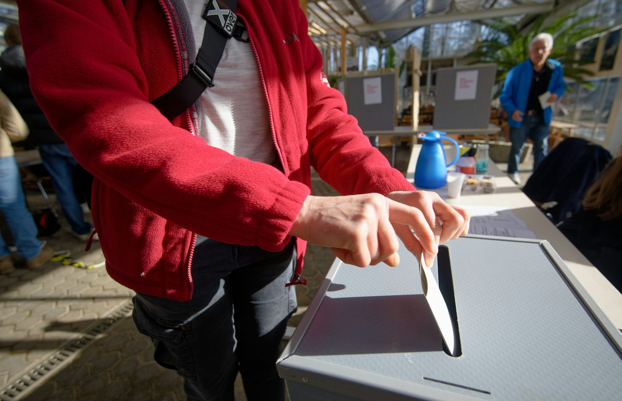 Ein Mann gibt in einem Wahllokal in einem Gewächshaus eines Gartenbaubetriebs in Köln-Hahnwald seine Stimme ab.