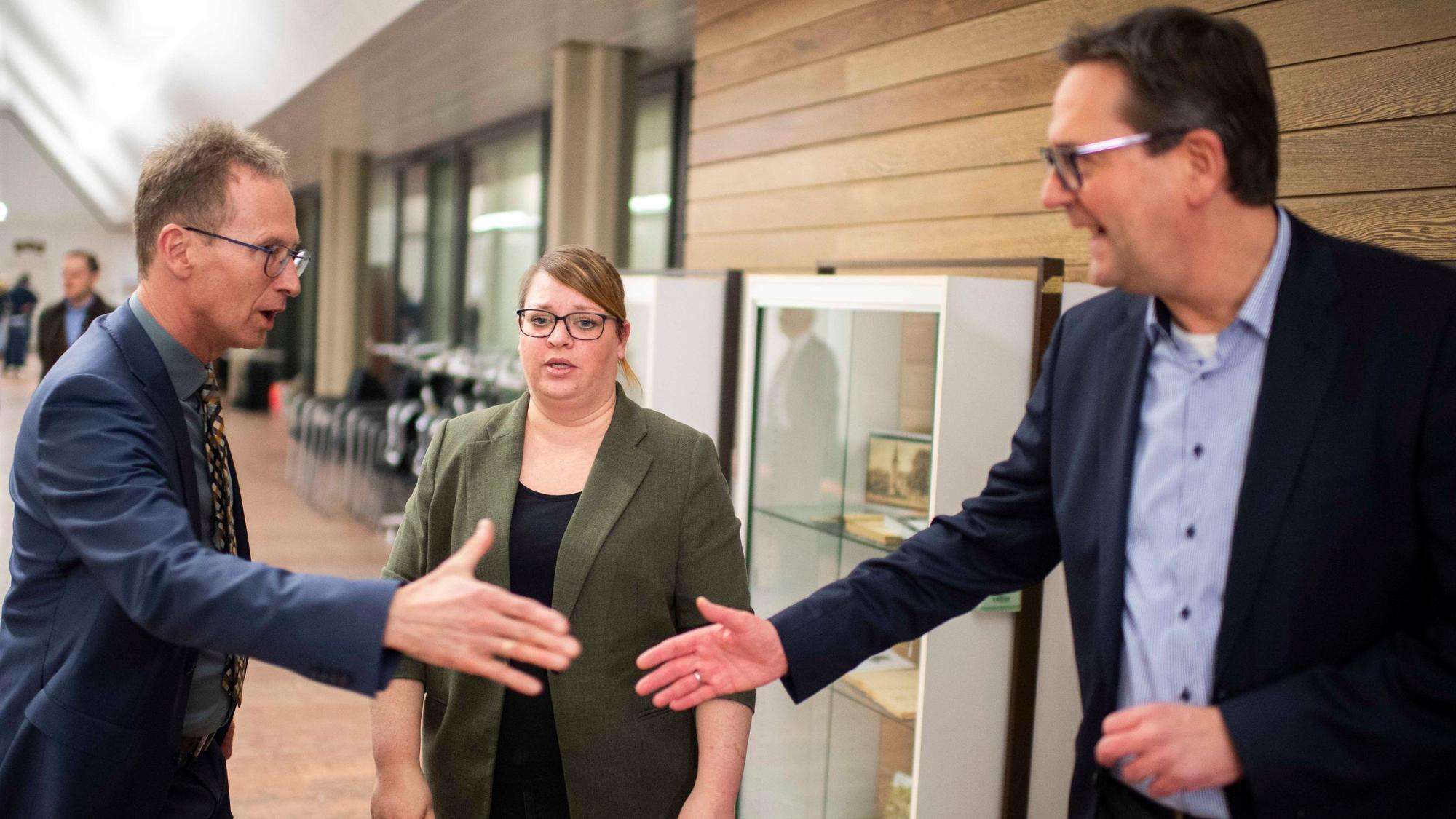 Im Vordergrund reicht Markus Herbrand Detlev Seif die Hand, Andrea Kanonenberg schaut zu. Rüdiger Lucassen ist auf dem Foto nicht zu sehen.