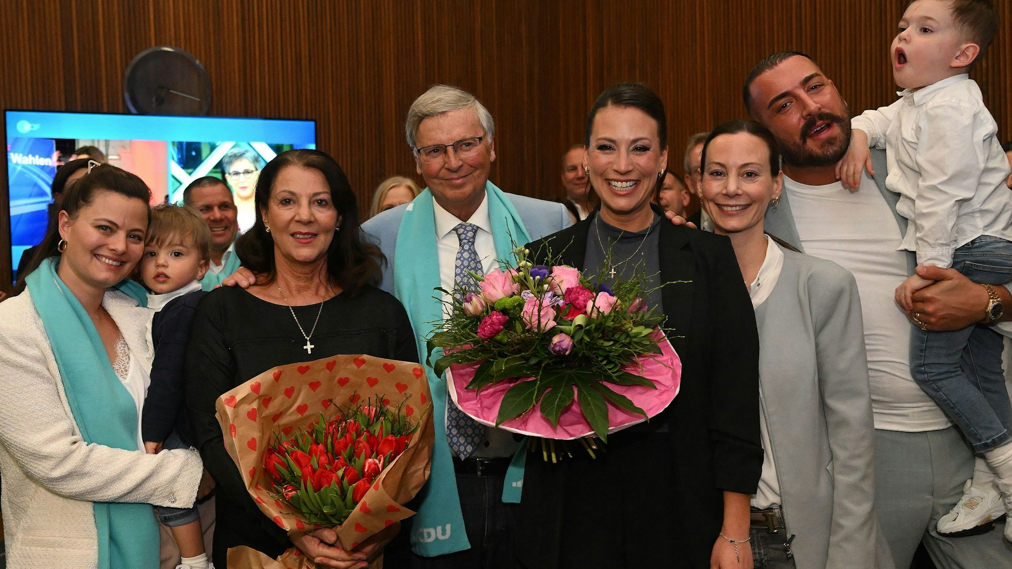 Caroline Bosbach steht mit ihrer Familie und Blumen in der Hand am Wahlabend (23.2.) im Kreishaus ihrer Heimatstadt Bergisch Gladbach.