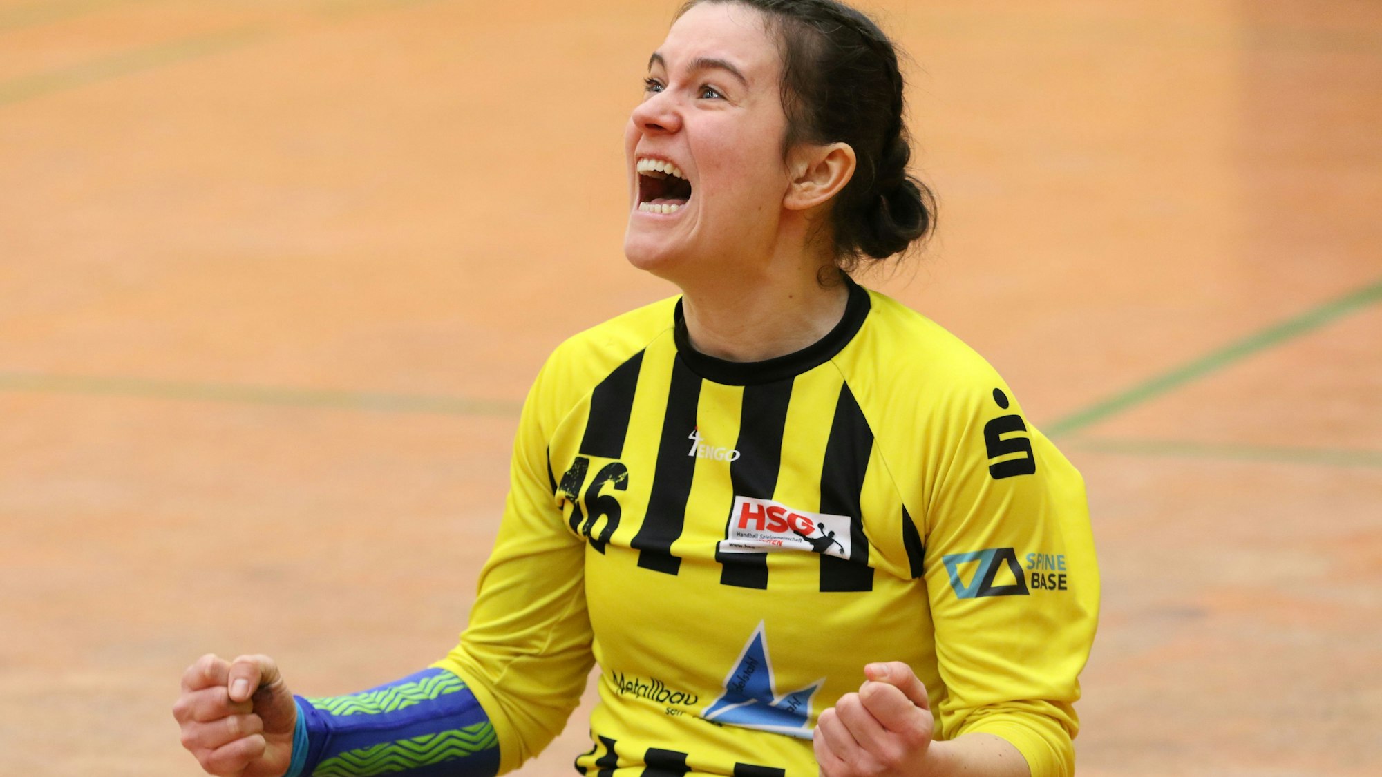 Die Handballtorhüterin jubelt mit geballten Fäusten.