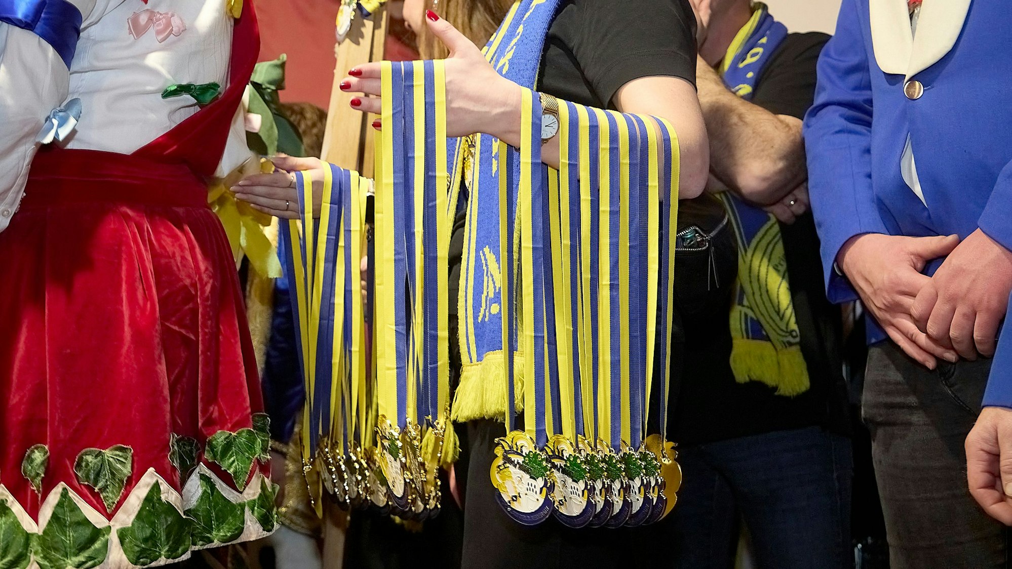 Beim Prinzentreffen hat ein Helfer zahlreiche Karnevalsorden über seinen Arm gehängt.