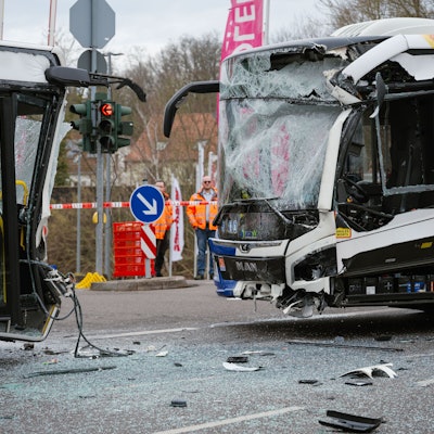 Zwei Linienbusse mit komplett zerstörten Fronten stehen sich auf einer Kreuzung gegenüber.