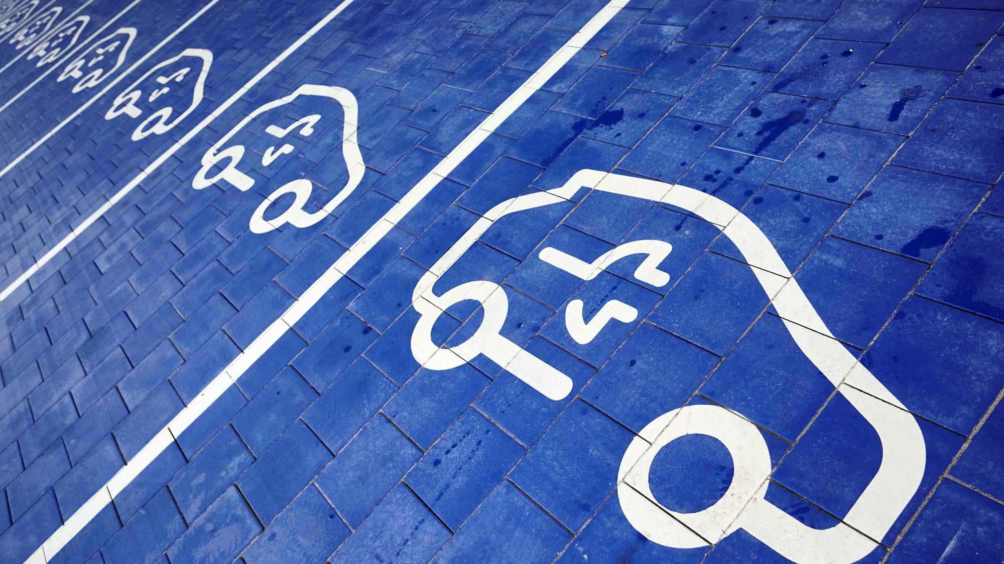 Pictogramme für E-Autos sind auf dem Boden des bislang größten Schnellladeparks des Energieunternehmens EnBW für E-Autos zu sehen. Aber auch umgekehrt geht es: Das E-Auto kann auch Strom abgeben.