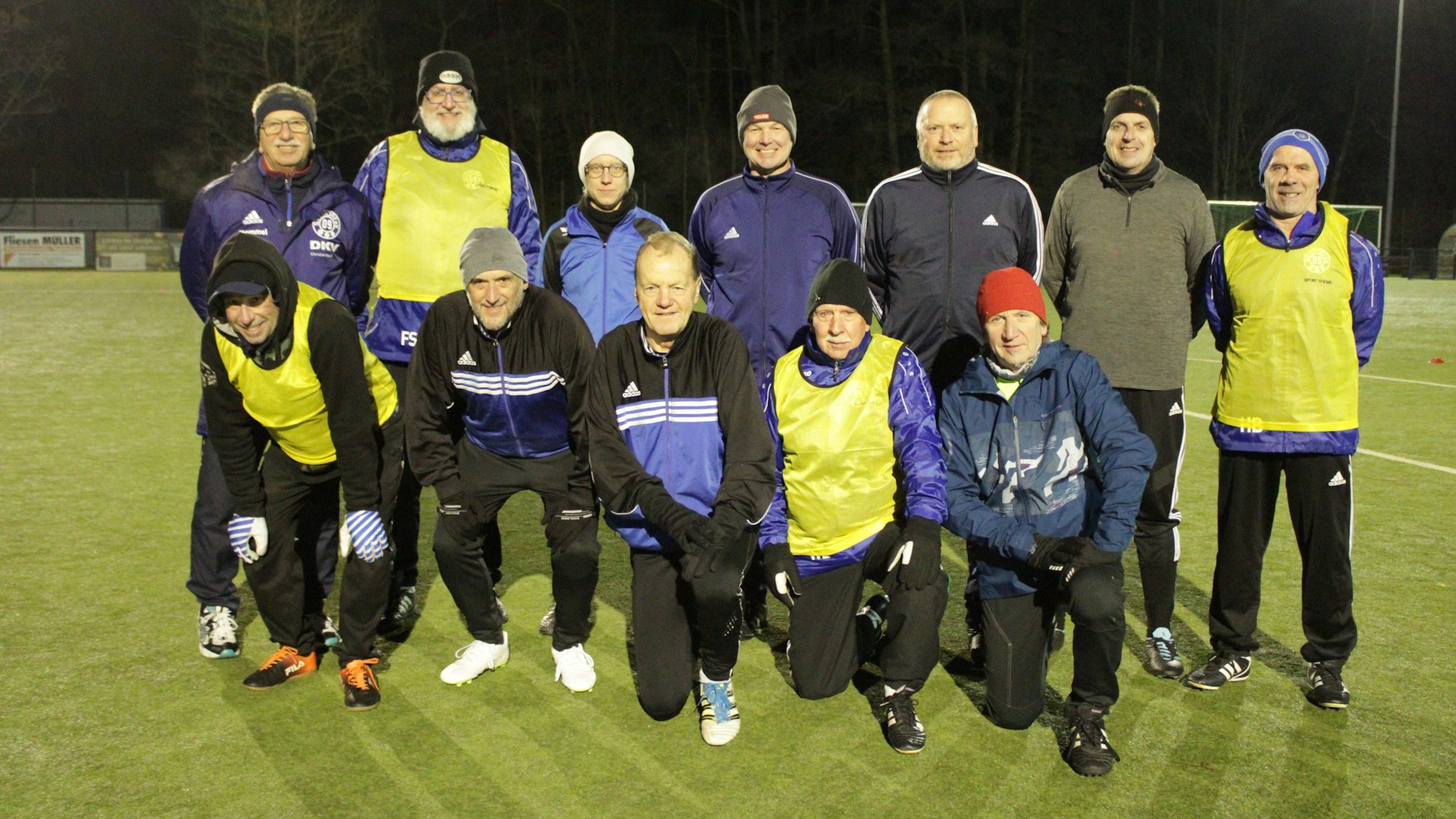 Eine Fußballmannschaft bestehend aus 11 Männern und einer Frau posiert für ein Gruppenfoto