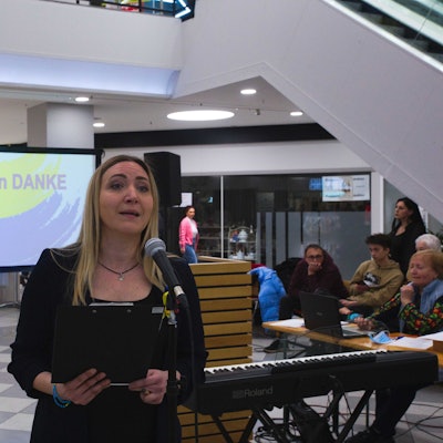 Eine Frau steht an einem Mikrofon.