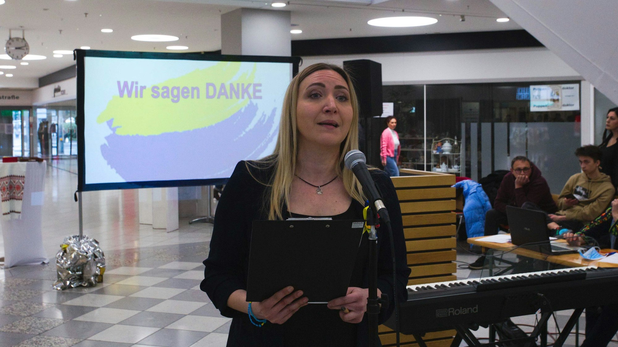 Eine Frau steht an einem Mikrofon.
