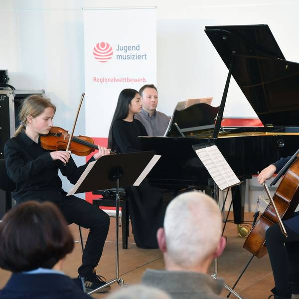 Das Foto zeigt drei junge Musikerinnen und Musiker.