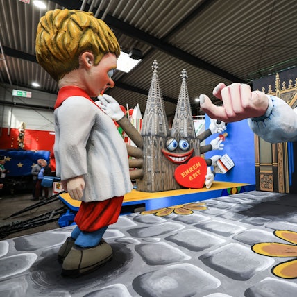 Der Motivwagen zum Thema Missbrauch in der Kirche steht beim Richtfest des Kölner Rosenmontagszuges in der Wagenhalle.