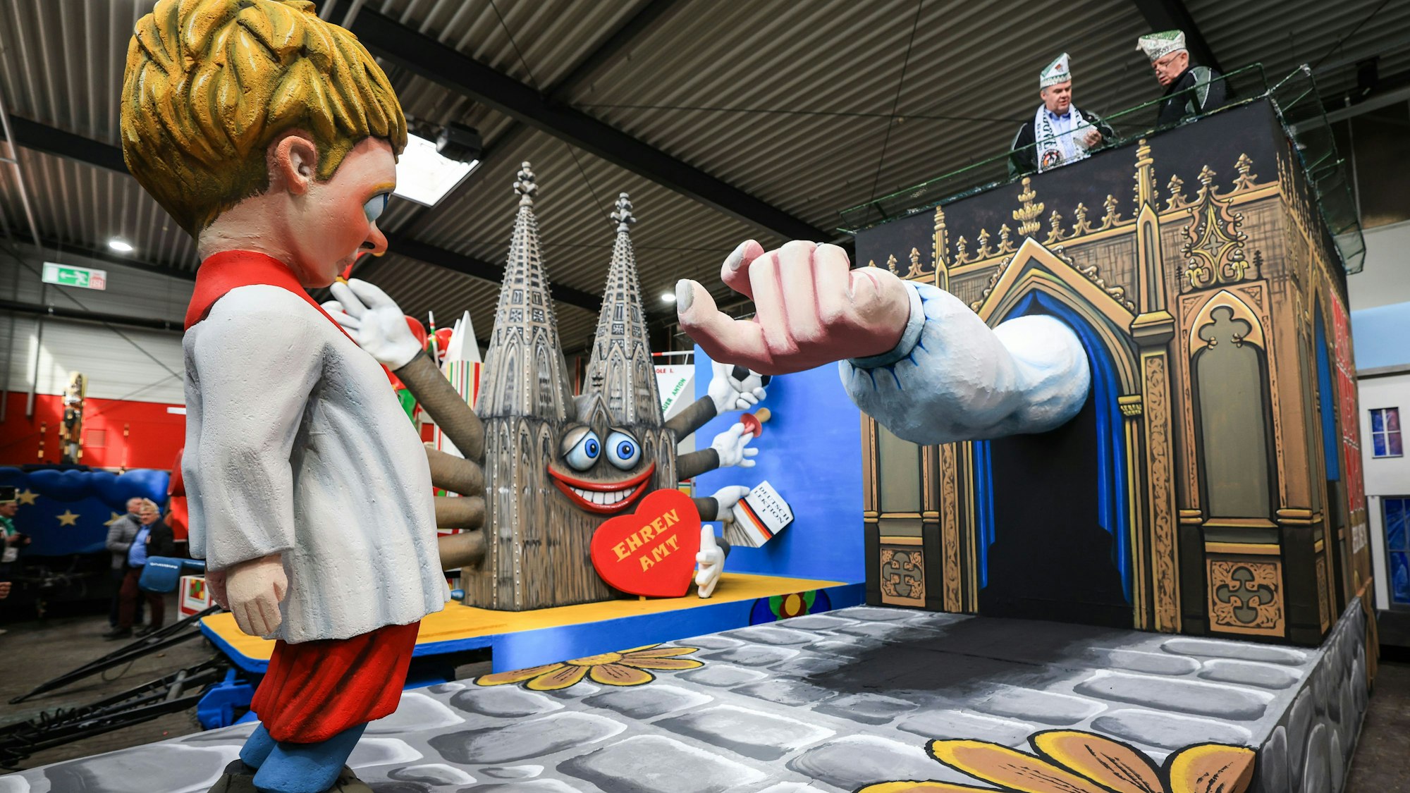 Der Motivwagen zum Thema Missbrauch in der Kirche steht beim Richtfest des Kölner Rosenmontagszuges in der Wagenhalle.