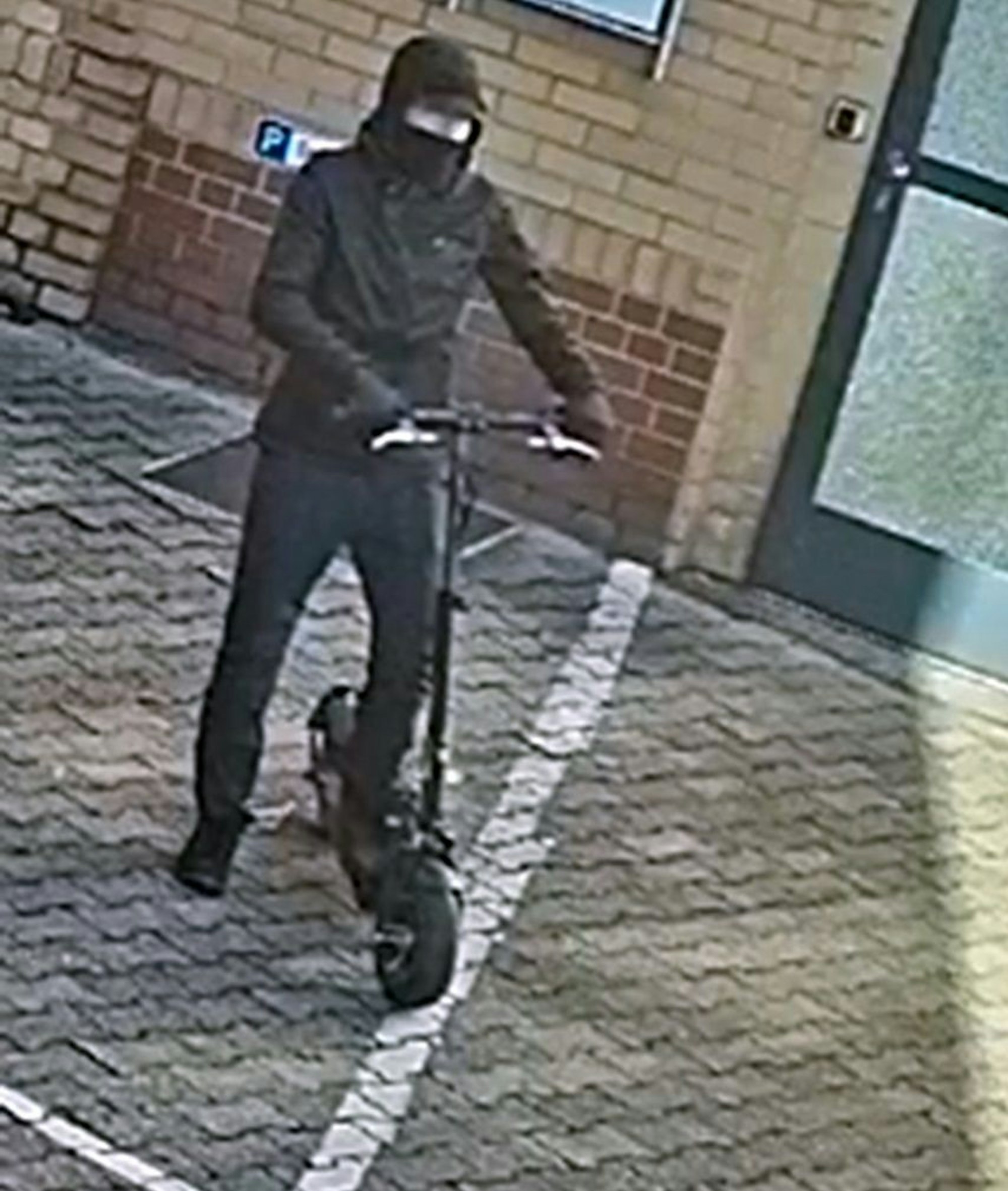 Der Tatverdächtige, der auf dem E-Scooter von der Kamera aufgenommen wurde.