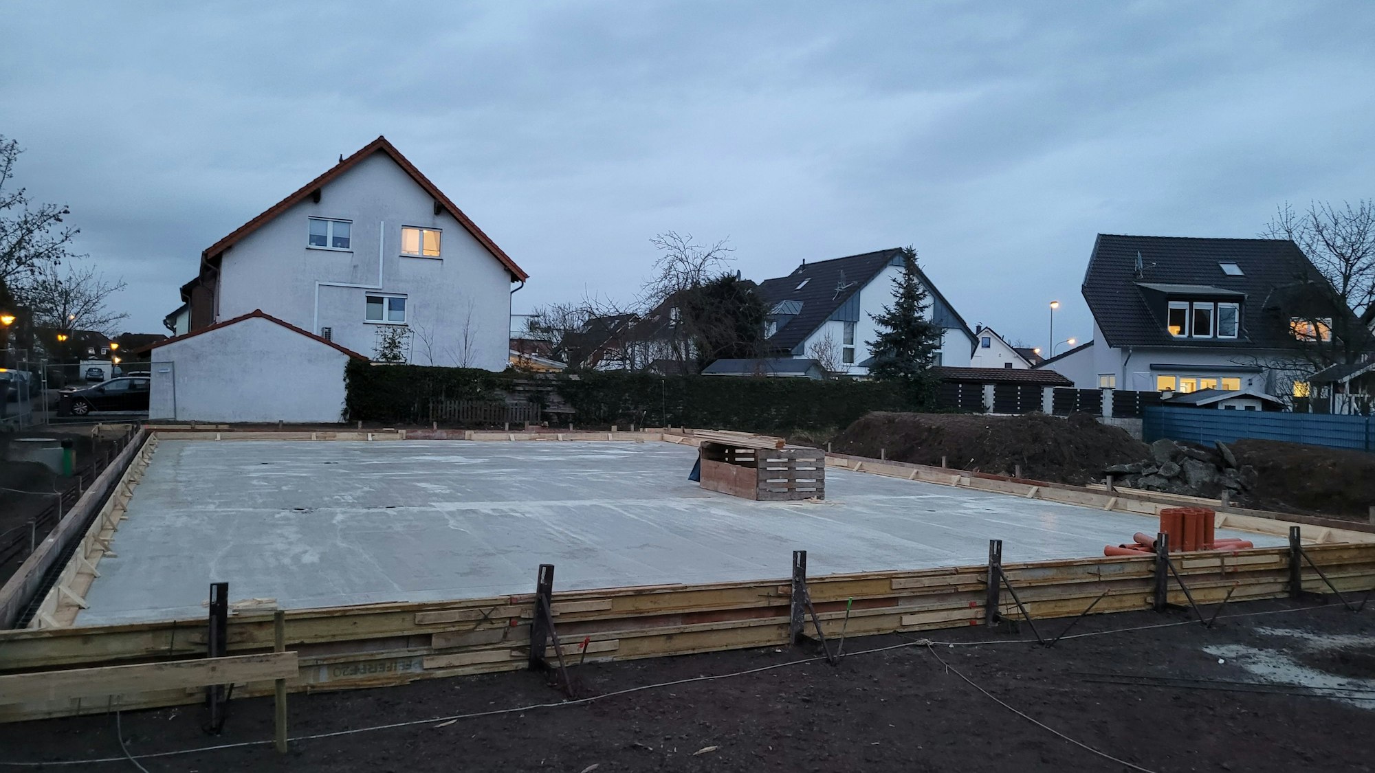 Eine Baustelle, im Hintergrund Wohnhäuser.