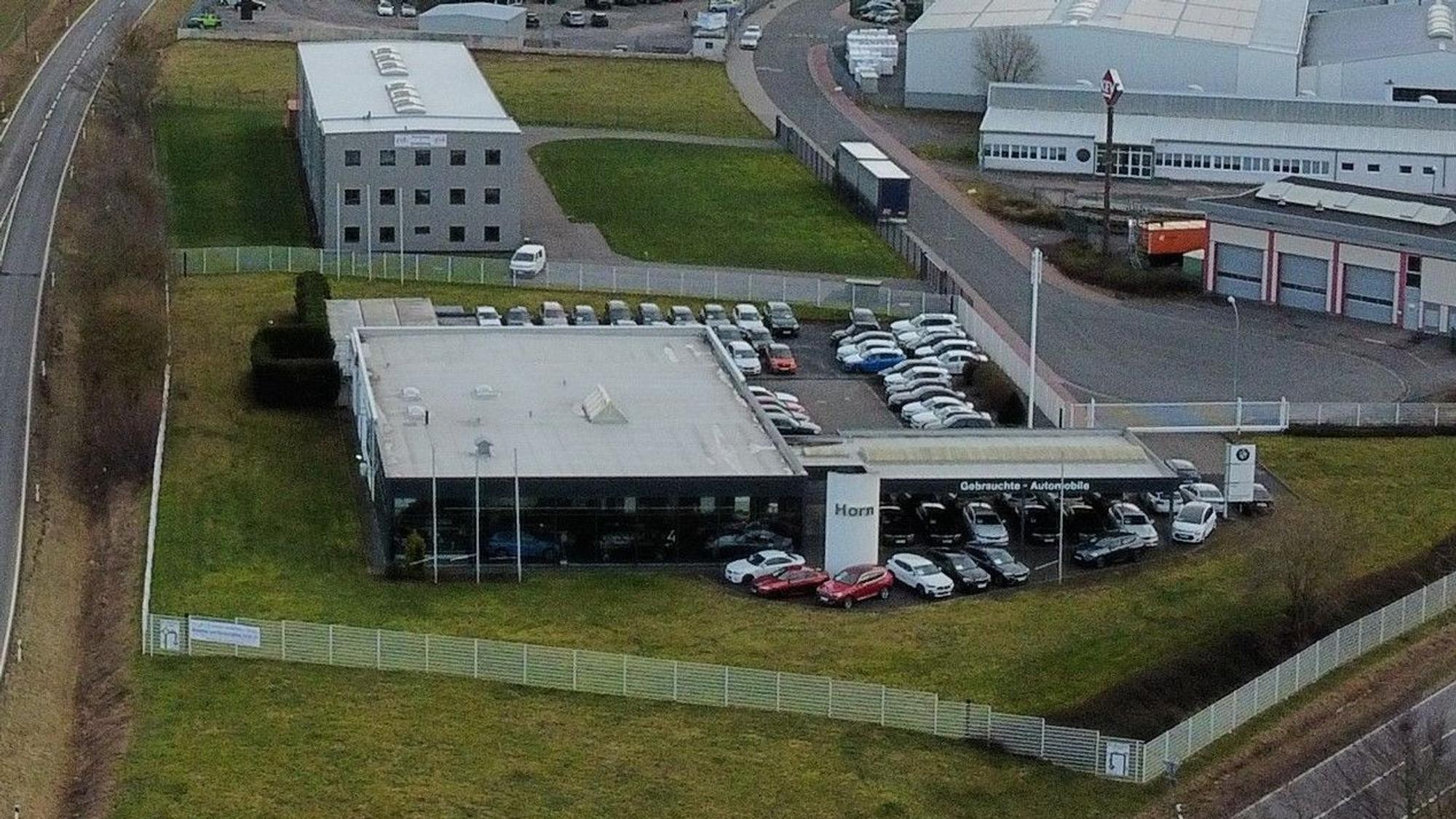 Das Foto zeigt das Grundstück mit dem Autohaus aus der Vogelperspektive.