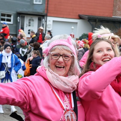 Zwei kostümierte Damen gehen in einem Karnevalszug in Waldbröl mit.