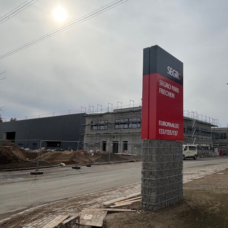 Auf dem Bild ist die Baustelle des Segro Parks und ein Firmenschild zu sehen.