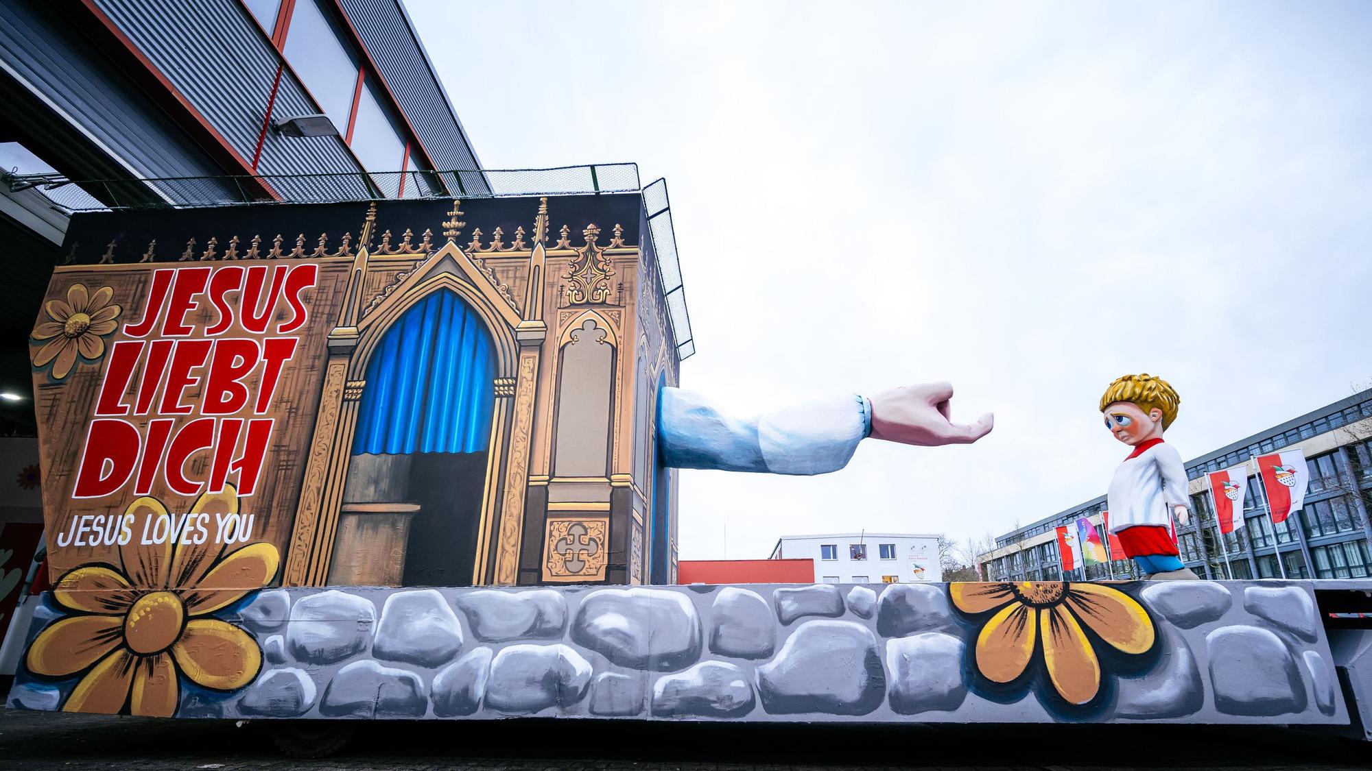 Der Persiflagewagen zum Thema Missbrauch in der Kirche steht beim Richtfest des Kölner Rosenmontagszuges in der Wagenhalle.