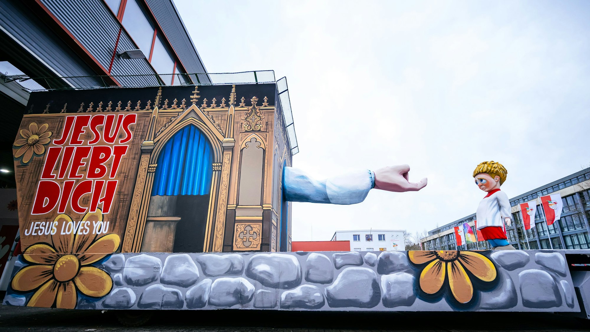 Der Persiflagewagen zum Thema Missbrauch in der Kirche steht beim Richtfest des Kölner Rosenmontagszuges in der Wagenhalle.