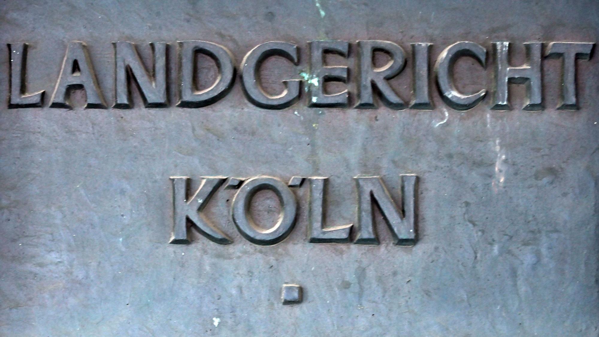 Das Bild zeigt ein Schild weist auf das Landgericht in Köln hin.