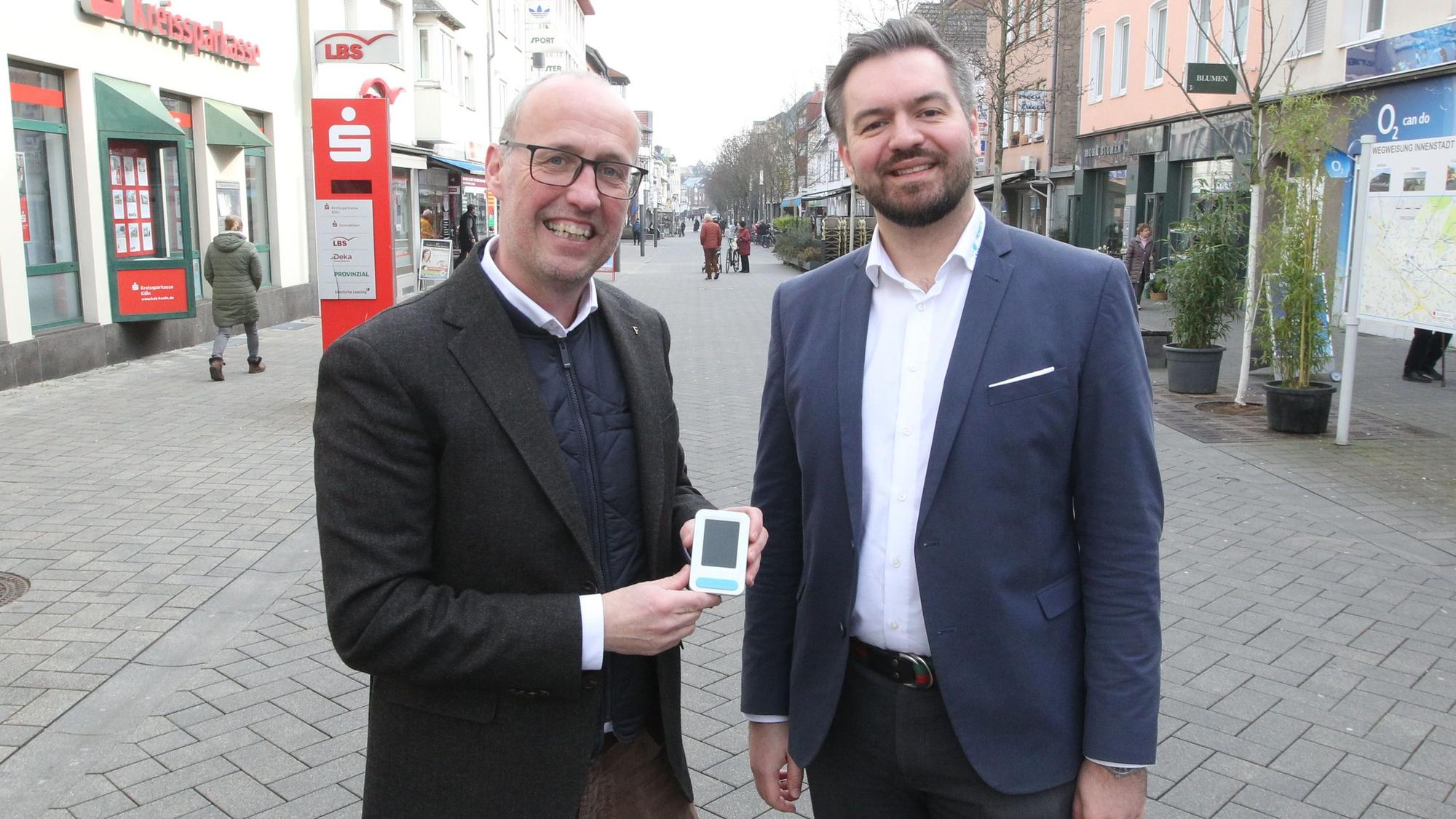 In Troisdorf können kleine Kameras an den Scheiben verschiedener Geschäfte die Menschenströme erkennen.
Trowista-Chef Alexander Miller (rechts) und Wirtschaftsförderer Stephan Frings stellen das Gerät vor.