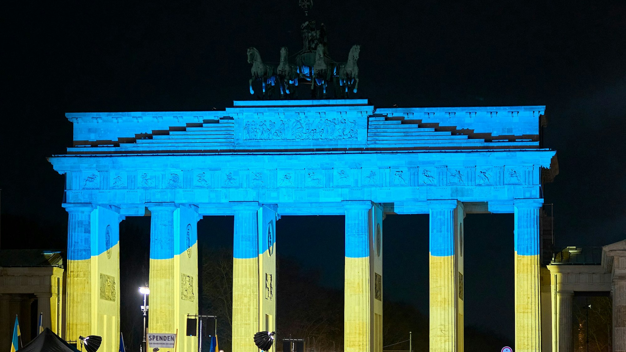 Das Brandenburger Tor wird vor einer Gedenkveranstaltung zum dritten Jahrestag des russischen Angriffs auf die Ukraine in den ukrainischen Nationalfarben angestrahlt.