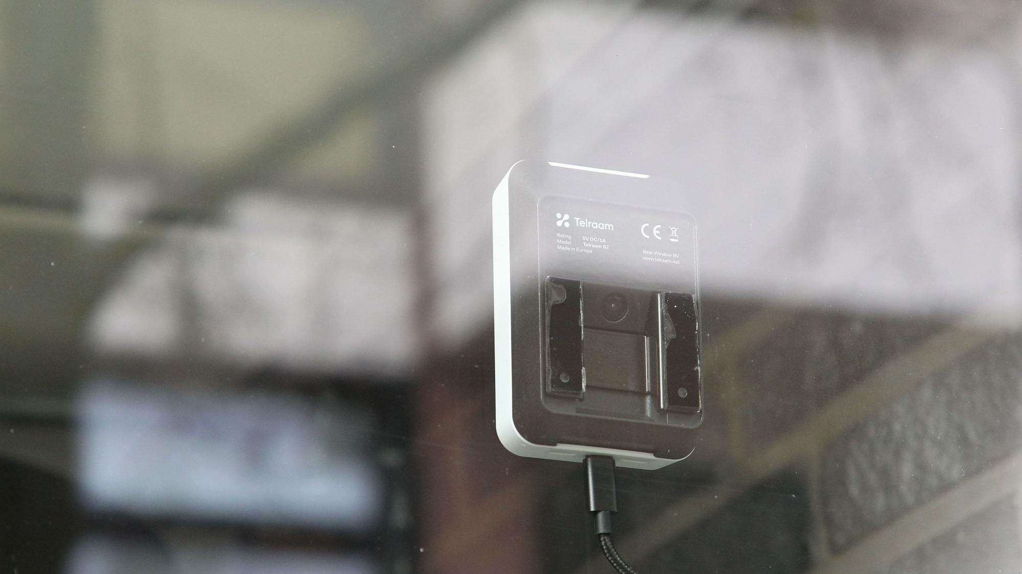 Hinter einer Schaufensterscheibe ist ein kleines Messgerät mit Sensor montiert.