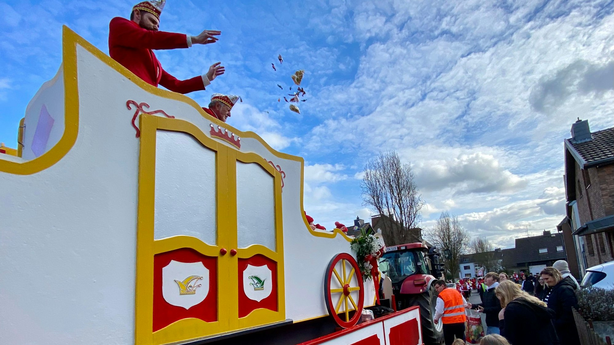 Zu sehen sind ein Karnevalswagen und Zuschauer am Straßenrand.