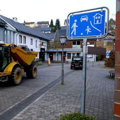 Ein schweres Baufahrzeug fährt durch die Spielstraße.