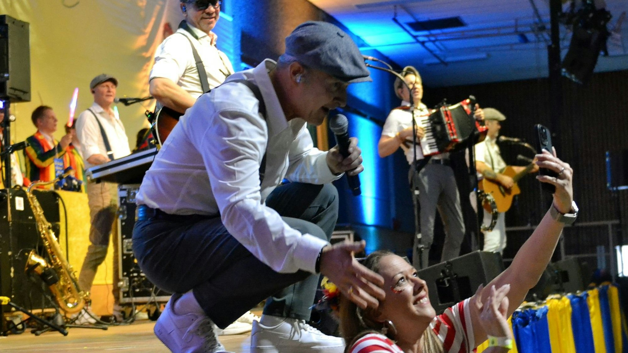 Frank Reudenbach ist auf der Bühne in die Hocke gegangen für ein Selfie mit einer Besucherin.