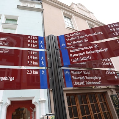 Auf roten Tafeln stehen Richtungsangaben und Entfernungen zu Zielen in der Stadt Bad Honnef.
