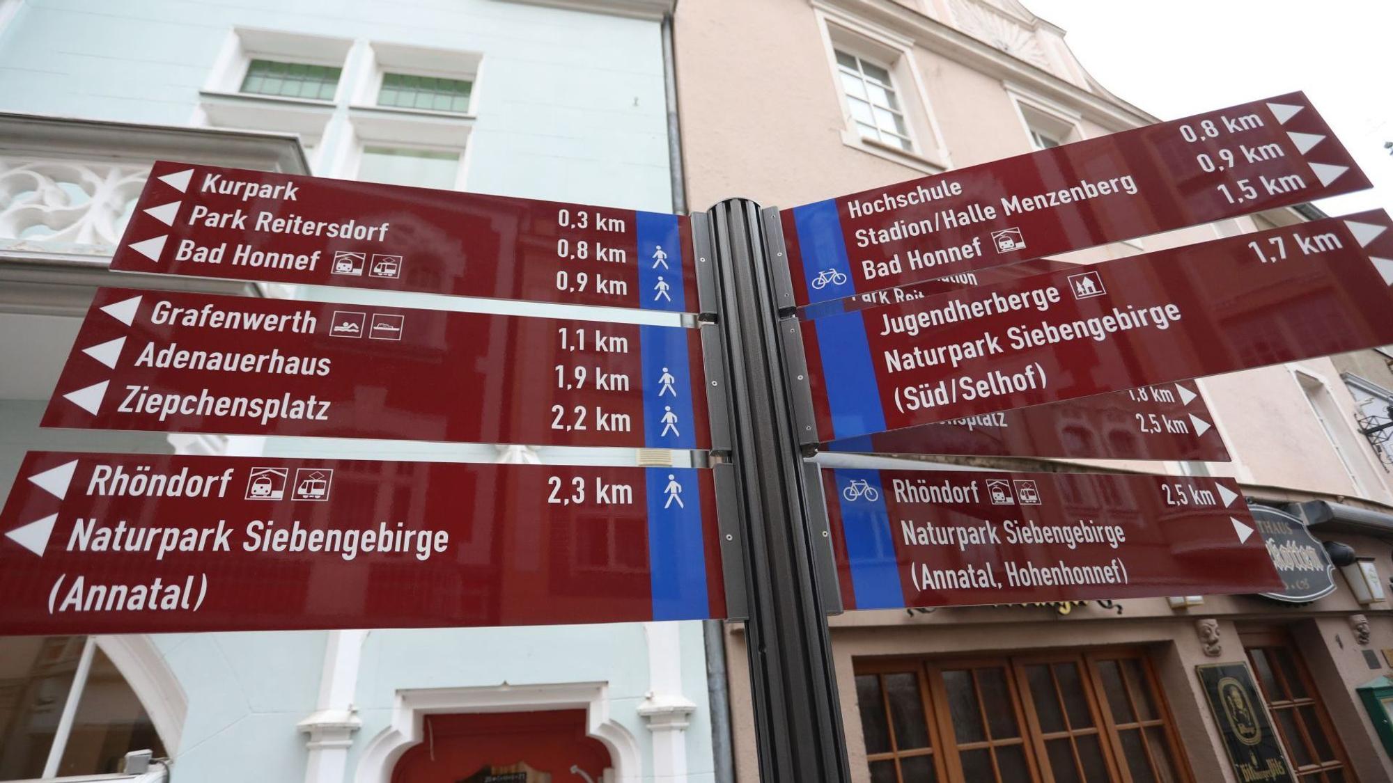 Auf roten Tafeln stehen Richtungsangaben und Entfernungen zu Zielen in der Stadt Bad Honnef.