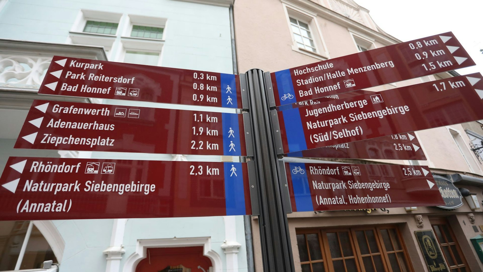 Auf roten Tafeln stehen Richtungsangaben und Entfernungen zu Zielen in der Stadt Bad Honnef.