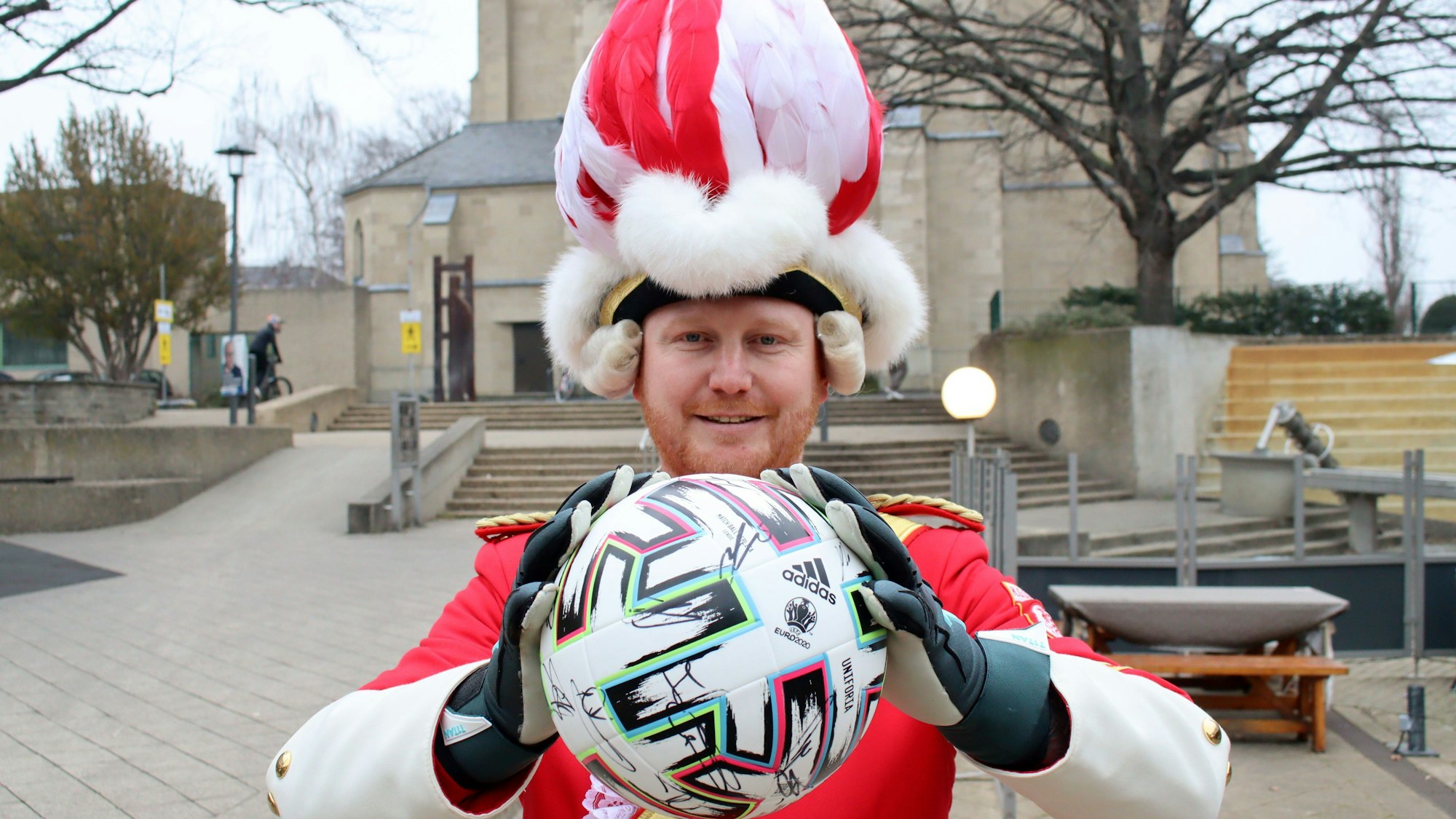 Das Bild zeigt Dirk Lamb, der in rot-weißer Uniform einen Fußball in den Händen hält.