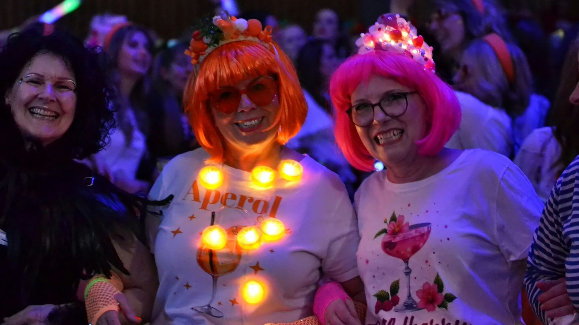 Zwei Frauen im Publikum tragen Lichterketten.