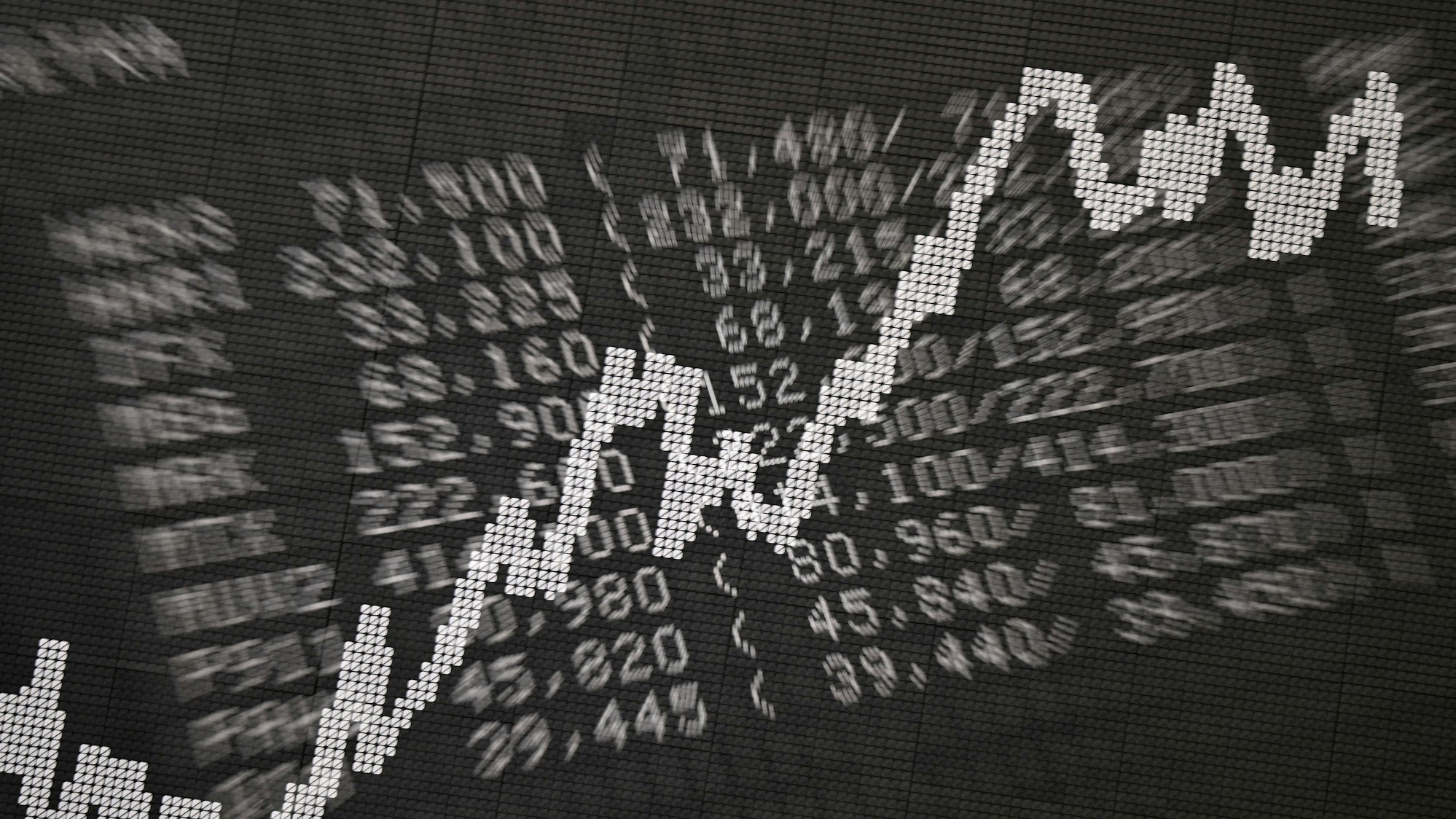 Die Doppelbelichtung zeigt eine Anzeigetafel im Handelssaal der Frankfurter Wertpapierbörse mit Kursen von Unternehmen im Xetra-Handel sowie der Dax-Kurve